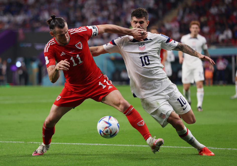 Soccer Football - FIFA World Cup Qatar 2022 - Group B - United States v Wales - Ahmad Bin Ali Stadium, Al Rayyan, Qatar - November 21, 2022 Wales' Gareth Bale in action with Christian Pulisic of the U.S. REUTERS/Pedro Nunes