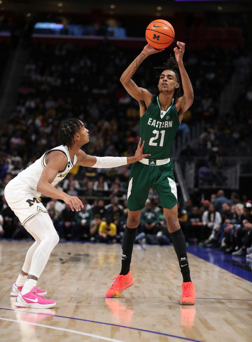 Eastern Michigan forward Emoni Bates passes against Michigan guard Kobe Bufkin during the first half on Friday, Nov. 11, 2022, at Little Caesars Arena.