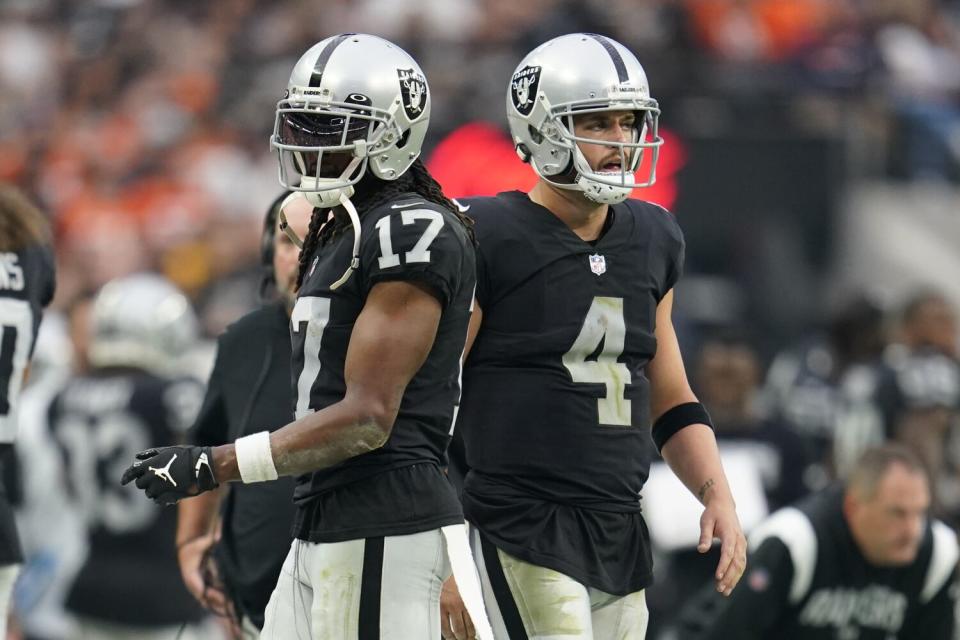 Las Vegas Raiders wide receiver Davante Adams and quarterback Derek Carr look on from the sidelines.