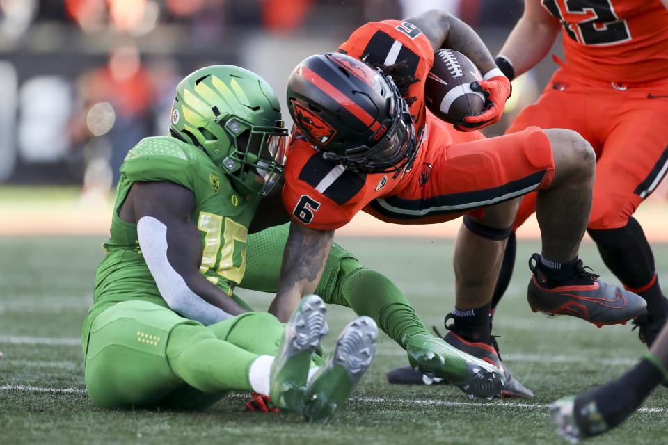 Oregon State running back Damien Martinez (6) is brought down by Oregon defensive back Jamal Hill (19) on Saturday, Nov 26, 2022, in Corvallis, Ore. (AP Photo/Amanda Loman)