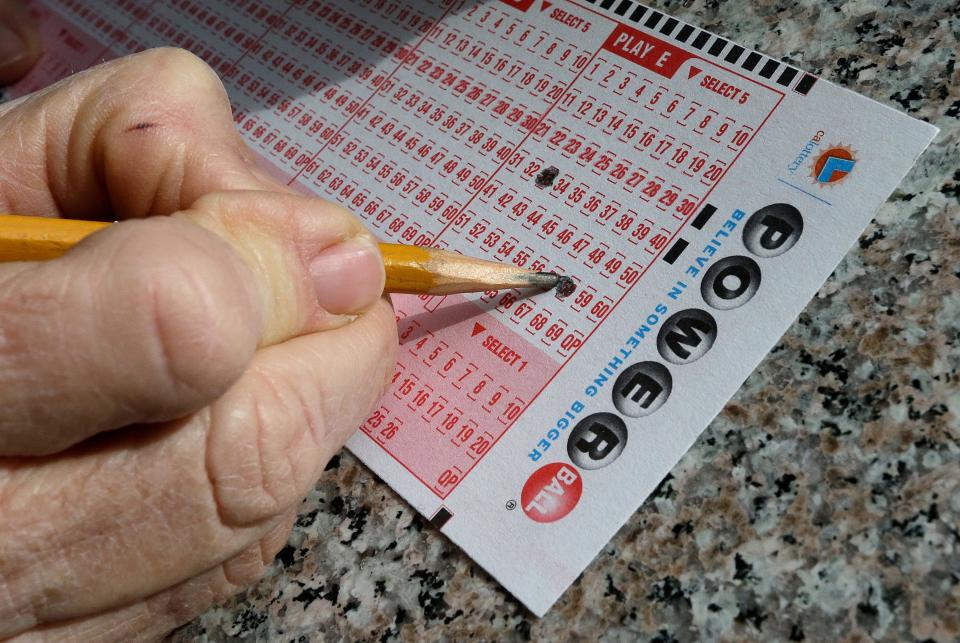 A lottery player fills out choices on a Powerball form.