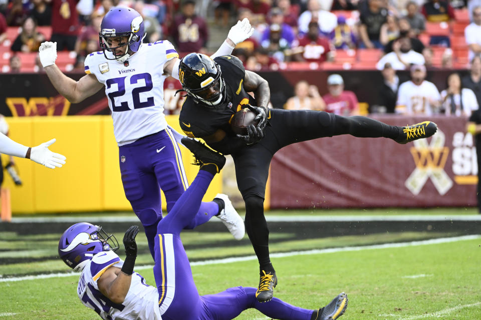 Nov 6, 2022; Landover, Maryland, USA; Washington Commanders wide receiver Curtis Samuel (10) makes a touchdown reception between Minnesota Vikings safety Harrison Smith (22) and safety Camryn Bynum (24) during the second half at FedExField. Mandatory Credit: Brad Mills-USA TODAY Sports