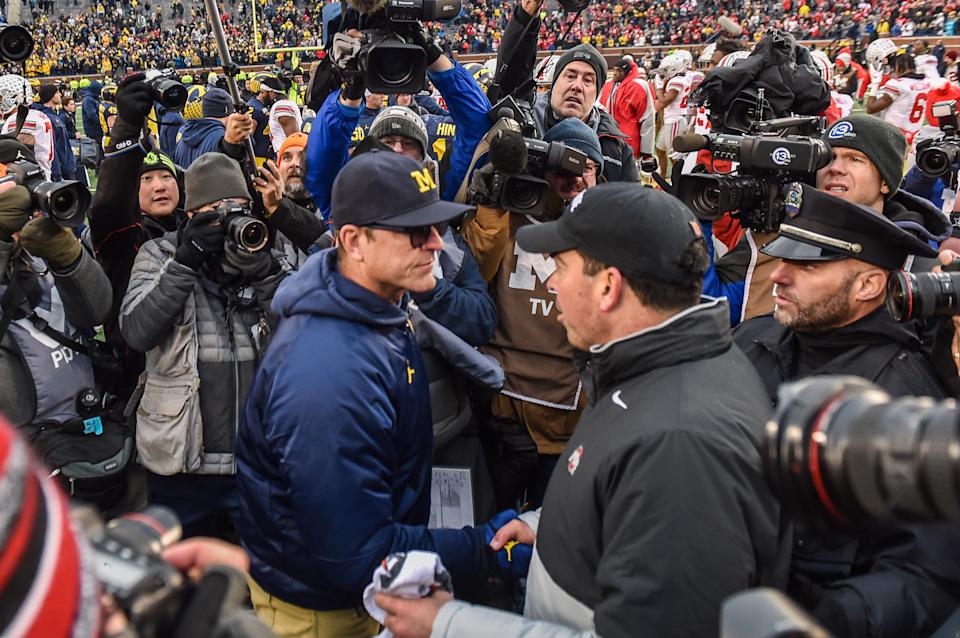 Ohio State coach Ryan Day (R) shakes hands with Michigan coach Jim Harbaugh after a college football game on Nov. 30, 2019. (Aaron J. Thornton/Getty Images)