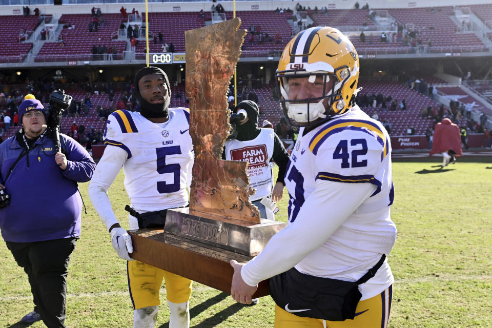 LSU players Jay Ward (5) and Lane Blue (42) carry 