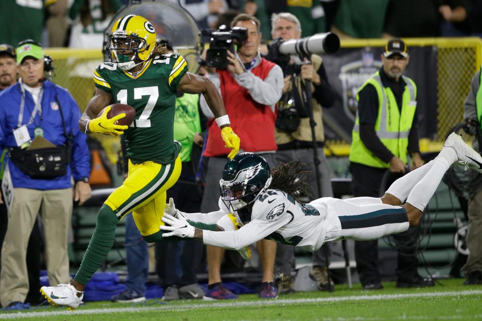 Green Bay Packers wide receiver Davante Adams runs from the defense of Philadelphia Eagles cornerback Sidney Jones after making a catch during the first half of an NFL football game Thursday, Sept. 26, 2019, in Green Bay, Wis.