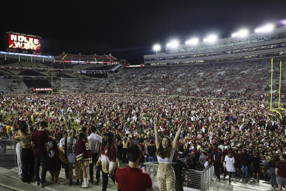 Florida State fans gather on the field after the team's 45-38 win over Florida on Friday, Nov. 25, 2022, in Tallahassee, Fla. (AP Photo/Phil Sears)