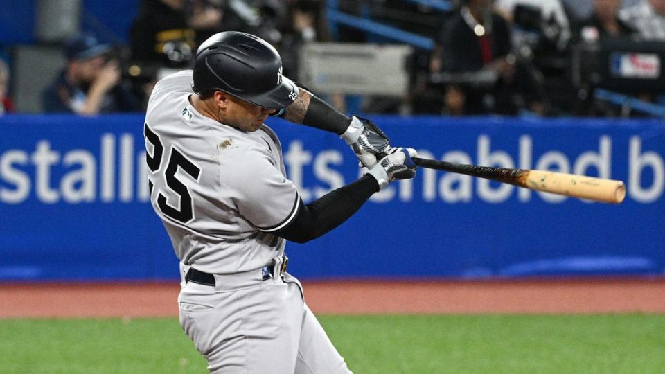 Gleyber Torres swing follow-through side angle in Toronto grey uniform