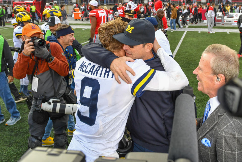 COLUMBUS, OHIO - NOVEMBER 26: Head Football Coach Jim Harbaugh (R) hugs Quarterback J.J. McCarthy #9 (L) of the Michigan Wolverines after a college football game against the Ohio State Buckeyes at Ohio Stadium on November 26, 2022 in Columbus, Ohio. The Michigan Wolverines won the game 45-23 over the Ohio State Buckeyes and clinched the Big Ten East. (Photo by Aaron J. Thornton/Getty Images)