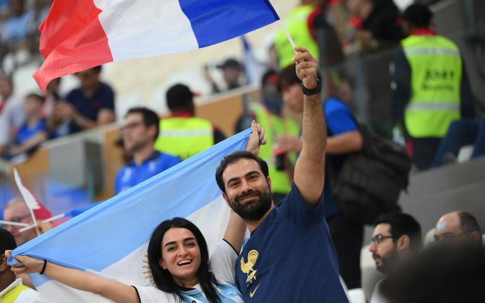 A supporter of Argentina and another of France cheer on the stands ahead of the Qatar 2022 World Cup football final match between Argentina and France at Lusail Stadium - Getty Images/Franck Fife