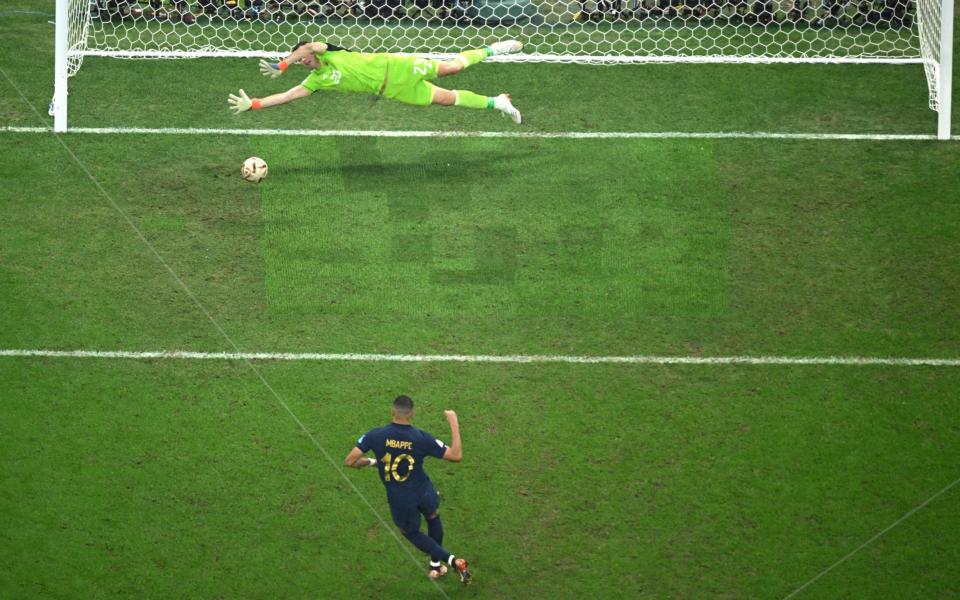 Kylian Mbappe of France scores the team's first goal from the penalty spot past Emiliano Martinez of Argentina - Getty Images Europe