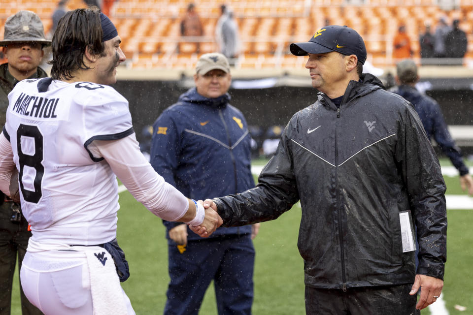 West Virginia head coach Neal Brown shakes quarterback Nicco Marchiol (8) hand after the NCAA college football game against Oklahoma State in Stillwater, Okla., Saturday Nov. 26, 2022. (AP Photo/Mitch Alcala)