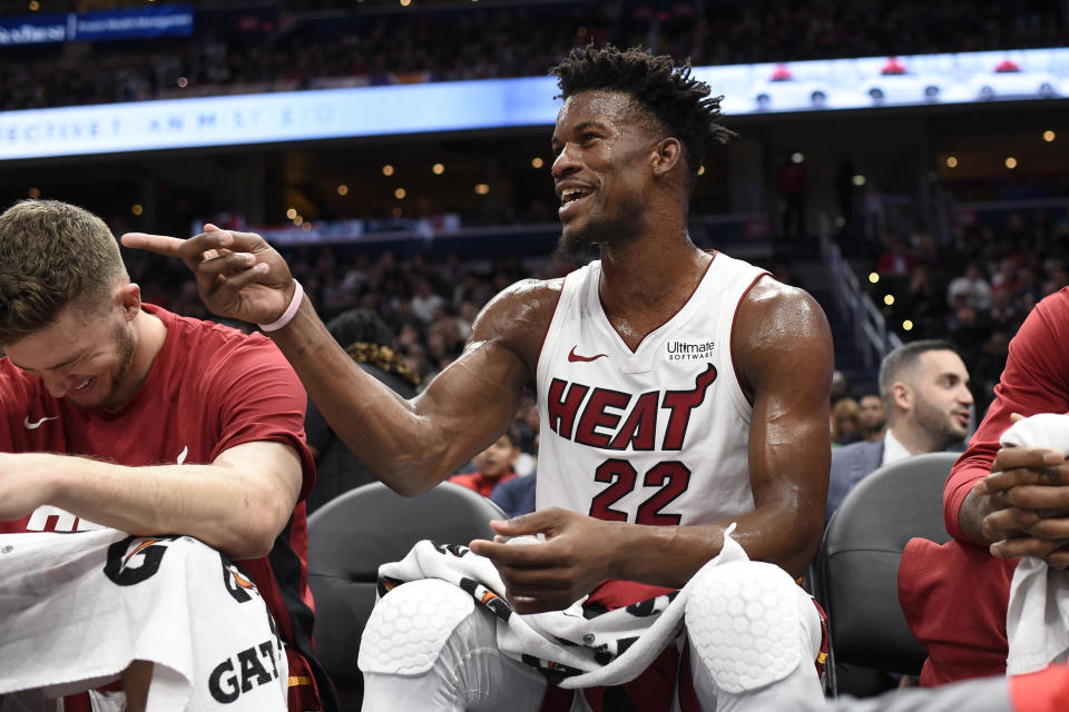 Miami Heat forward Jimmy Butler (22) points as he sits on the bench during the first half of an NBA basketball game against the Washington Wizards, Monday, Dec. 30, 2019, in Washington. The Wizards won 123-105. (AP Photo/Nick Wass)