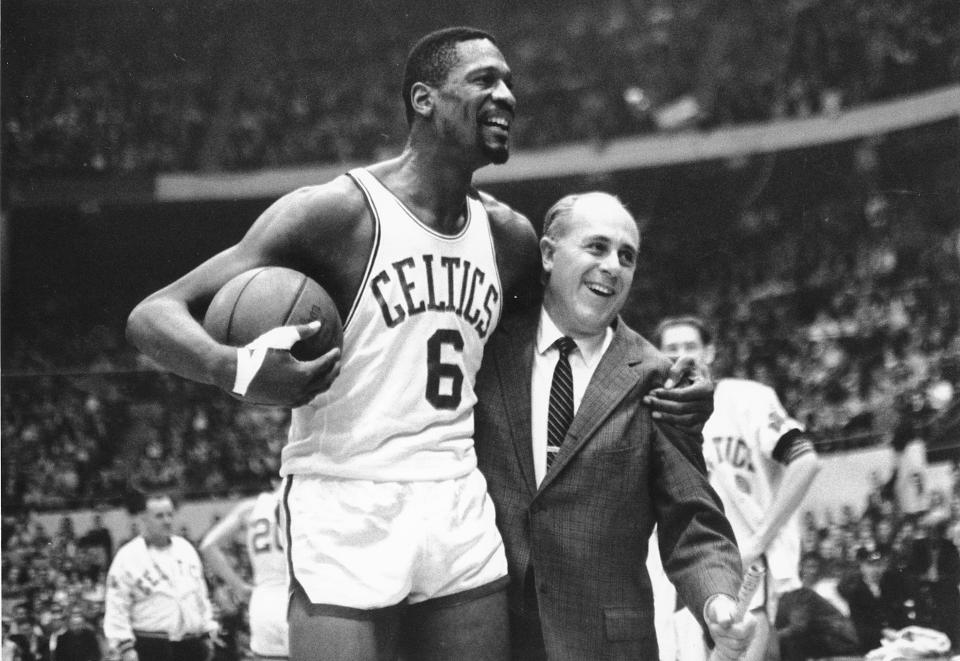 FILE - Bill Russell, left, star of the Boston Celtics is congratulated by coach Arnold 