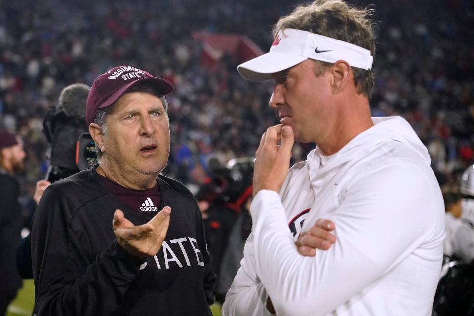 Mississippi State coach Mike Leach, left, talks with Mississippi coach Lane Kiffin before an NCAA college football game in Oxford on Thursday, Nov. 24.