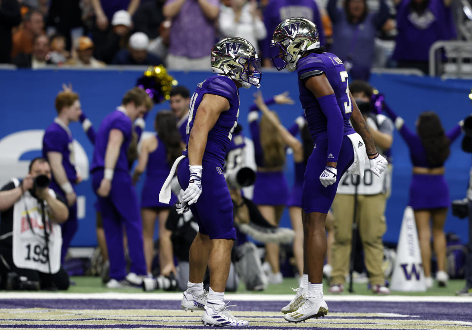 SAN ANTONIO, TX - DECEMBER 29: Washington Huskies running back Wayne Taulapapa (21) and Washington Huskies wide receiver Taj Davis (3) celebrate after Taulapapa scores a touchdown against the Texas Longhorns during the Valero Alamo Bowl football game at the Alamodome on December 29, 2022 in San Antonio, TX. (Photo by Adam Davis/Icon Sportswire via Getty Images)