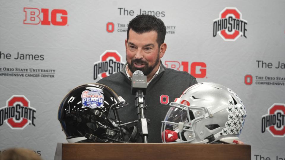 Dec 13, 2022; Columbus, Ohio, United States; With the 2022 Peach Bowl helmets in front of him, Ohio State football coach Ryan Day answers questions during a news conference at the Woody Hayes Athletic Center. Mandatory Credit: Doral Chenoweth/The Columbus Dispatch