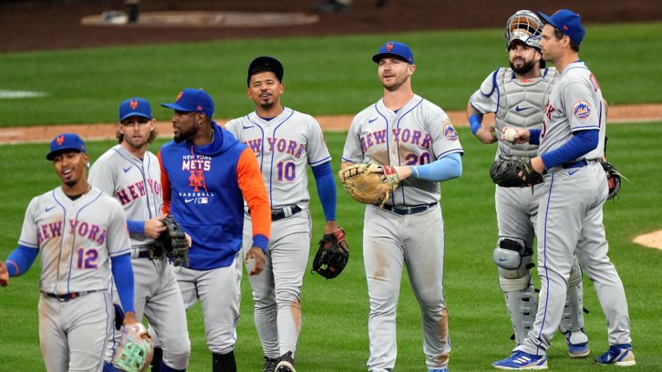 The New York Mets celebrate clinching a playoff berth after beating the Milwaukee Brewers 7-2.