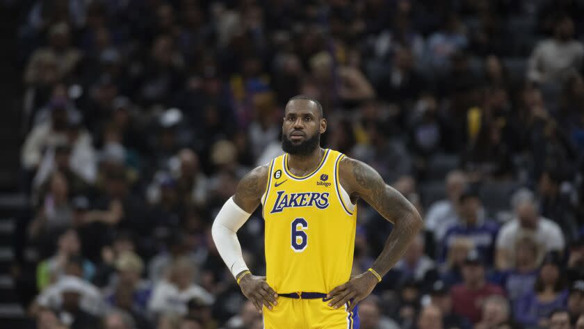 Los Angeles Lakers forward LeBron James stands on court with hands on hips.