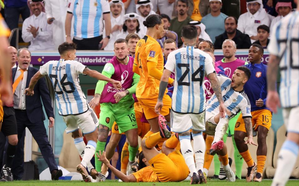 A fight breaks out between the Netherlands and Argentina players after Leandro Paredes kicked the ball into the substitutes bench - GETTY IMAGES