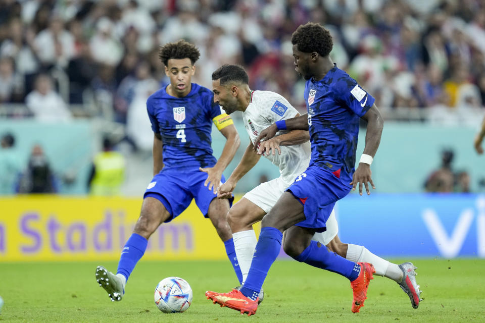 DOHA, QATAR - NOVEMBER 29: Tyler Adams of USA, Ali Karimi of Iran and Yunus Musah of USA battle for the ball during the FIFA World Cup Qatar 2022 Group B match between IR Iran and USA at Al Thumama Stadium on November 29, 2022 in Doha, Qatar. (Photo by Mohammad Karamali/DeFodi Images via Getty Images)