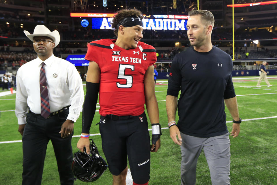 Mike Leach's first quarterback at Texas Tech, Kliff Kingsbury, talks with the school's greatest quarterback, Patrick Mahomes. (AP Photo/Ron Jenkins)