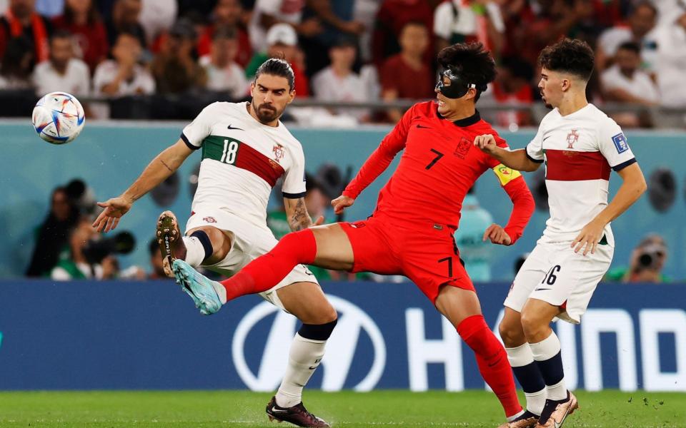 Son Heung-min of South Korea (C) in action against Vitinha (R) and Ruben Neves of Portugal during the FIFA World Cup - SHUTTERSTOCK