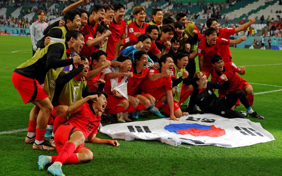 South Korea's players celebrate at the end of the Qatar 2022 World Cup Group H football match - AFP