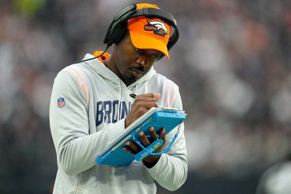 Defensive coordinator Ejiro Evero of the Denver Broncos takes notes in the fourth quarter against the Las Vegas Raiders at Allegiant Stadium on Oct. 2, 2022, in Las Vegas, Nevada.