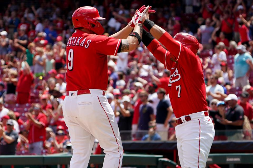 Cincinnati Reds first baseman Mike Moustakas (9) is congratulated by Cincinnati Reds designated hitter Donovan Solano (7) after hitting a three-run home during the third inning of a baseball game against the Tampa Bay Rays, Sunday, July 10, 2022, at Great American Ball Park in Cincinnati. The home run marked the 200th of his career.