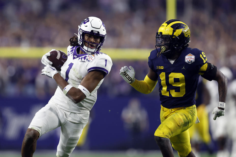 GLENDALE, ARIZONA - DECEMBER 31: Wide receiver Quentin Johnston #1 of the TCU Horned Frogs is tackled by defensive back Rod Moore #19 of the Michigan Wolverines during the second half of the Vrbo Fiesta Bowl at State Farm Stadium on December 31, 2022 in Glendale, Arizona. The Horned Frogs defeated the Wolverines 51-45. (Photo by Chris Coduto/Getty Images)