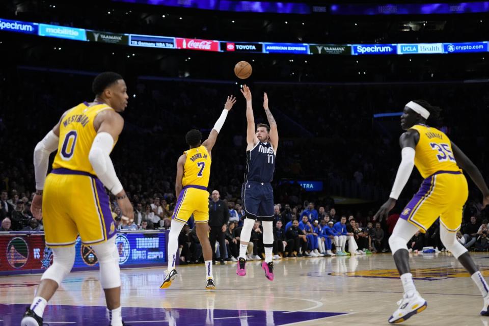 Tim Hardaway Jr. of the Mavericks shoots a three-pointer over Troy Brown Jr of the Lakers.