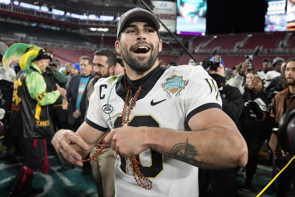 Wake Forest quarterback Sam Hartman throws beads to his teammates after being named Most Valuable Player of the Gasparilla Bowl NCAA college football game Friday, Dec. 23, 2022, in Tampa, Fla. (AP Photo/Chris O'Meara)