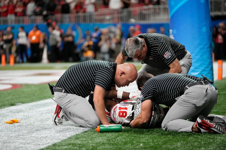 Ohio State Buckeyes wide receiver Marvin Harrison Jr. is tended to by medical staff after taking a hit from Georgia defensive back Javon Bullard.