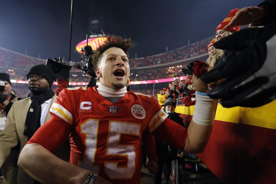 Kansas City Chiefs quarterback Patrick Mahomes celebrates with fans as he walks off the field.