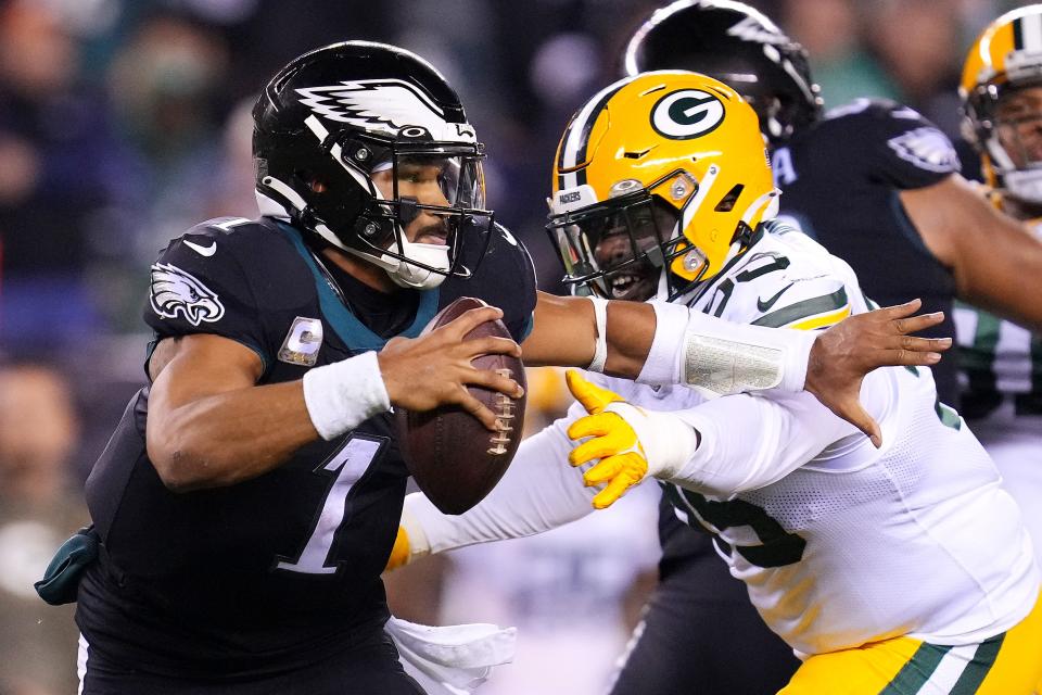 Philadelphia quarterback Jalen Hurts avoids pressure from Devonte Wyatt.
