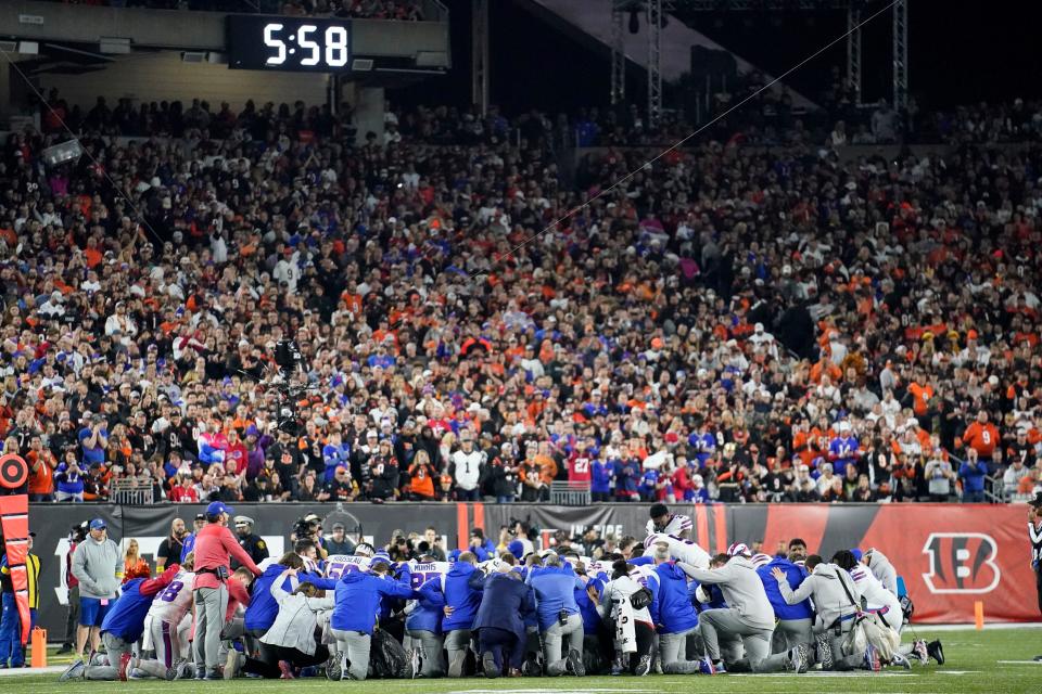 Buffalo Bills players and staff pray for Buffalo Bills' Damar Hamlin during the first half of an NFL football game against the Cincinnati Bengals, Monday, Jan. 2, 2023, in Cincinnati. The game has been postponed after Buffalo Bills' Damar Hamlin collapsed, NFL Commissioner Roger Goodell announced. (AP Photo/Joshua A. Bickel)