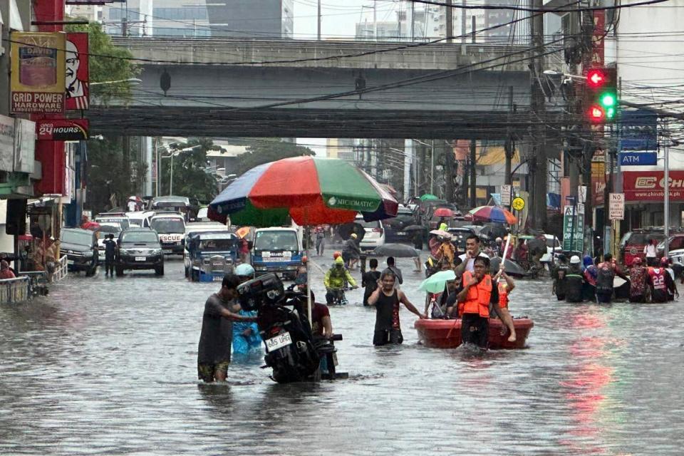 Streets flood from monsoon rains worsened by offshore typhoon Gaemi (AP)