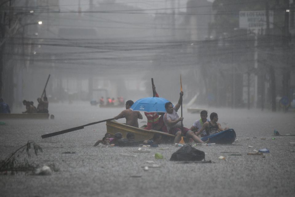 Rescuers paddle their boats along a flooded street in Manila amid heavy rains brought by Typhoon Gaemi (AFP via Getty Images)