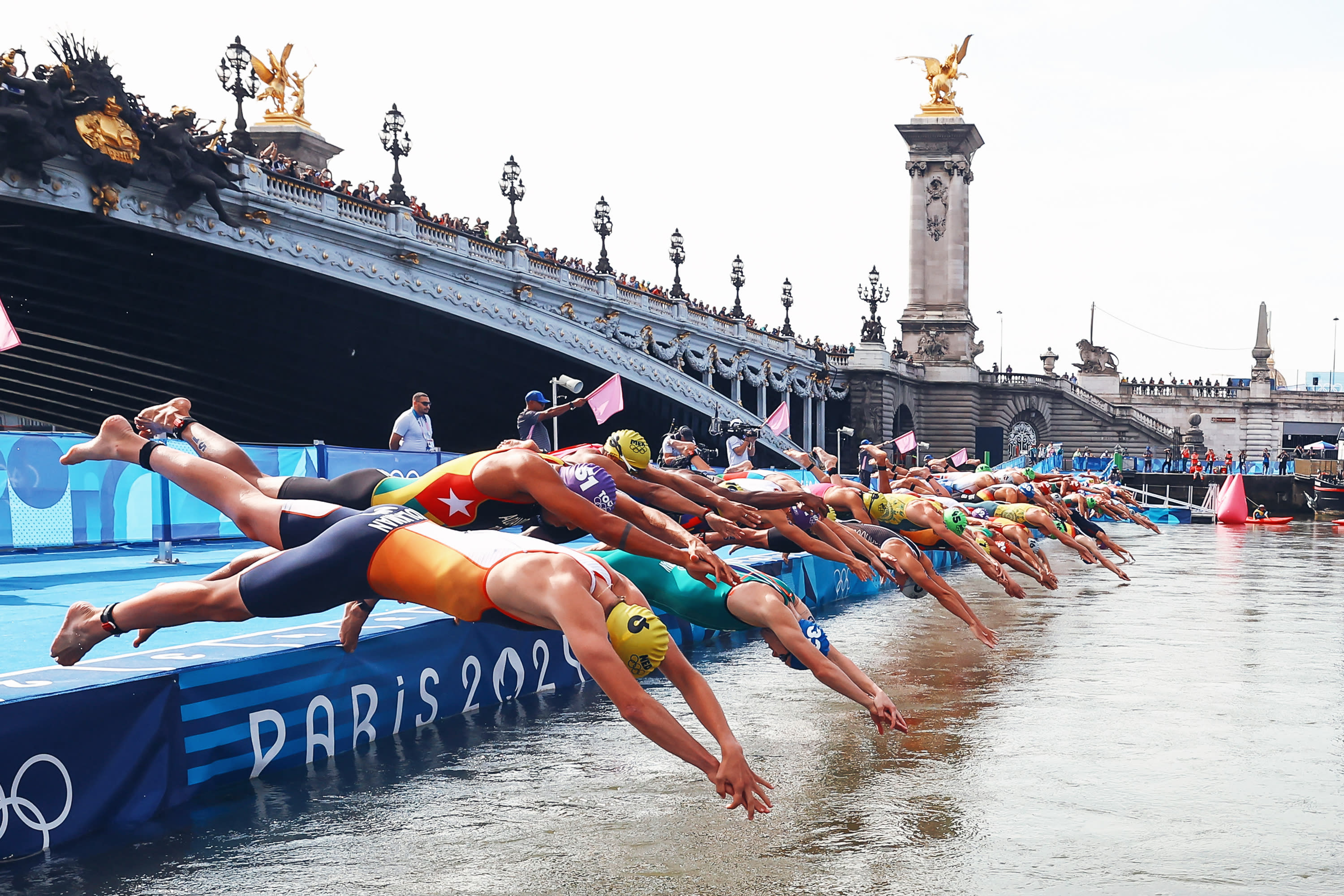 Athletes dive into the Seine river to start the swimming stage of the men's individual triathlon at the Paris 2024 Olympic Games in central Paris on July 31, 2024. (Photo by ANNE-CHRISTINE POUJOULAT/AFP via Getty Images) 