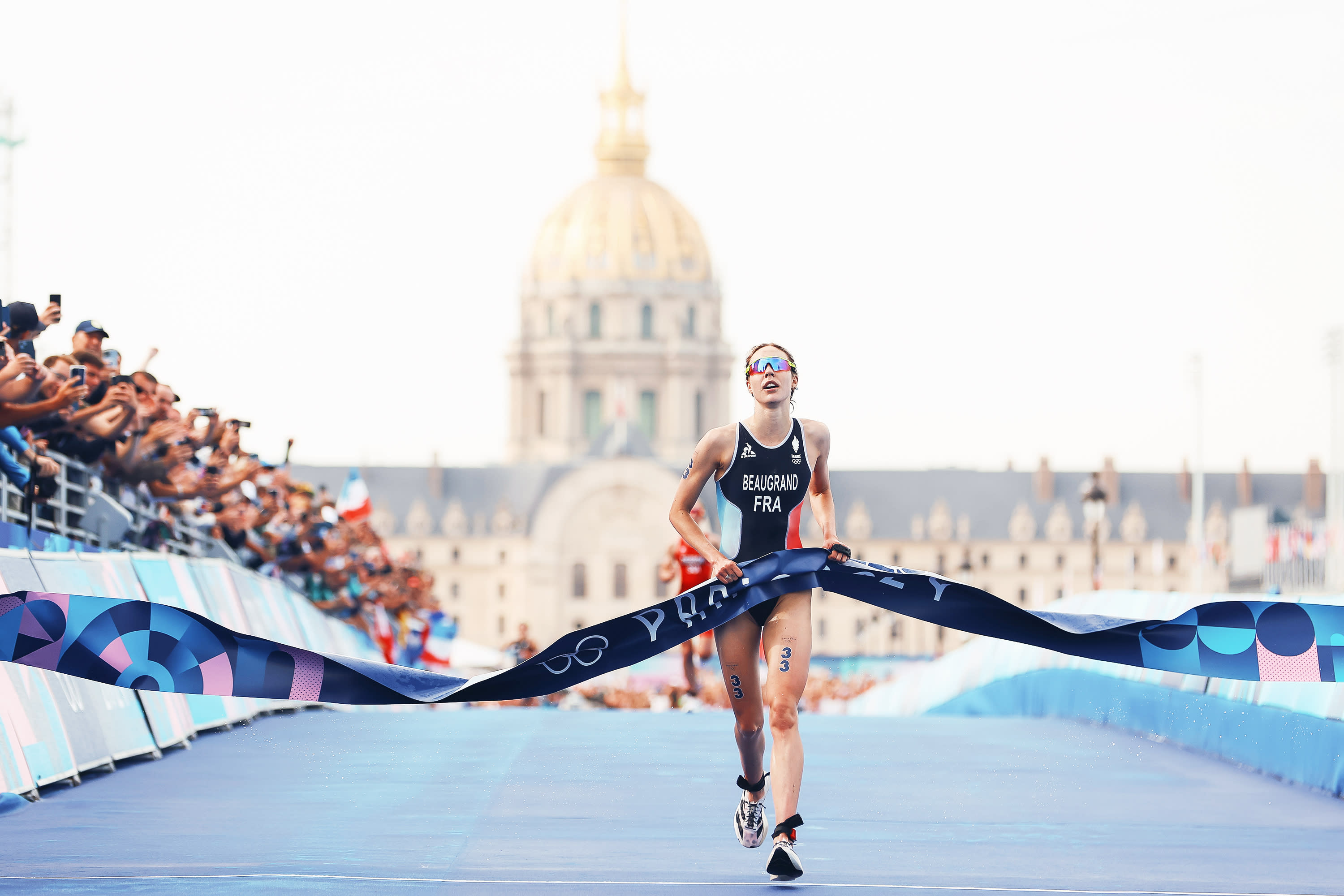 Cassandre Beaugrand of Team France crosses the finish tape to win the gold medal after competing in Women's Individual Triathlon on day five of the Olympic Games Paris 2024 at Pont Alexandre III on July 31, 2024 in Paris, France. (Photo by Michael Steele/Getty Images) 