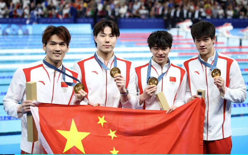 Gold medallists Xu Jiayu, Qin Haiyang, Sun Jiajun and Pan Zhanle with the Chinese flag