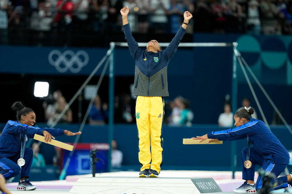 PARIS, FRANCE - AUGUST 5: Silver medalist Simone Biles of United States and bronze medalist Jordan Chiles of the United States celebrate gold medalist Rebeca Andrade of Brazil during the medal ceremony after the Women's Floor Exercise Final on day ten of the Olympic Games Paris 2024 at Bercy Arena on August 5, 2024 in Paris, France. (Photo by Daniela Porcelli/Eurasia Sport Images/Getty Images)