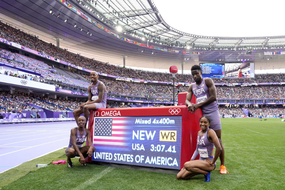 The United States team poses after setting a new world record in a 4 x 400 meters relay mixed round 1 heat at the 2024 Summer Olympics, Friday, Aug. 2, 2024, in Saint-Denis, France. (AP Photo/Bernat Armangue)