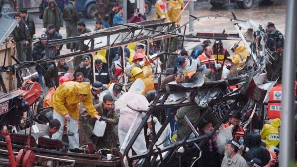 Israeli rescue teams search for bodies of victims inside the wreckage of a bus which was destroyed on March 3, 1996 by a suicide bomber in central Jerusalem. At least 20 Israeli were killed in the blast.