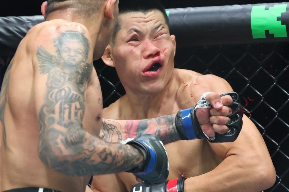 TOPSHOT - China's Li Jingliang (in red) is knocked out by Brazil's Carlos Prates in their men's welterweight division event of the Ultimate Fighting Championship (UFC) 305 at the Perth Arena in Perth on August 18, 2024. (Photo by COLIN MURTY / AFP) / -- IMAGE RESTRICTED TO EDITORIAL USE - STRICTLY NO COMMERCIAL USE -- (Photo by COLIN MURTY/AFP via Getty Images)