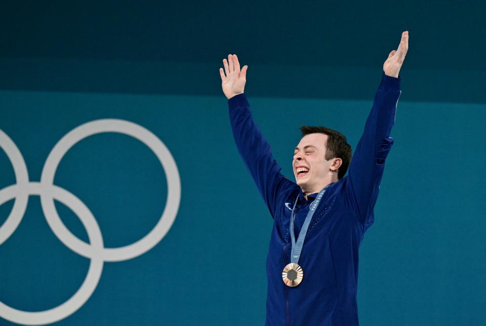 Bronze medallist US' Hampton Morris celebrates on the podium after the men's -61kg weightlifting event during the Paris 2024 Olympic Games at the South Paris Arena in Paris, on August 7, 2024. (Photo by Miguel MEDINA / AFP) (Photo by MIGUEL MEDINA/AFP via Getty Images)