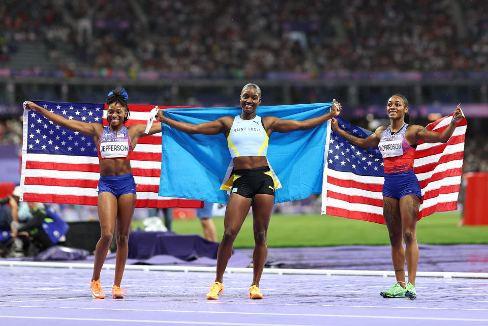 PARIS, FRANCE - AUGUST 03: Gold medalist Julien Alfred (C) of Team Saint Lucia, silver medalist Sha'Carri Richardson (R) of Team United States and bronze medalist Melissa Jefferson (L) of Team United States celebrate after competing in the on day eight of the Olympic Games Paris 2024 at Stade de France on August 03, 2024 in Paris, France. (Photo by Cameron Spencer/Getty Images)