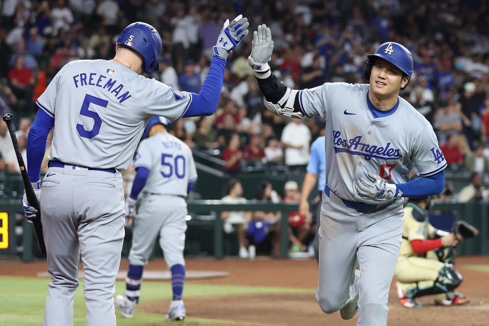 PHOENIX, ARIZONA - AUGUST 30: Shohei Ohtani #17 of the Los Angeles Dodgers high fives Freddie Freeman #5 after hitting a solo home run against the Arizona Diamondbacks during the eighth inning of the MLB game at Chase Field on August 30, 2024 in Phoenix, Arizona. (Photo by Christian Petersen/Getty Images)