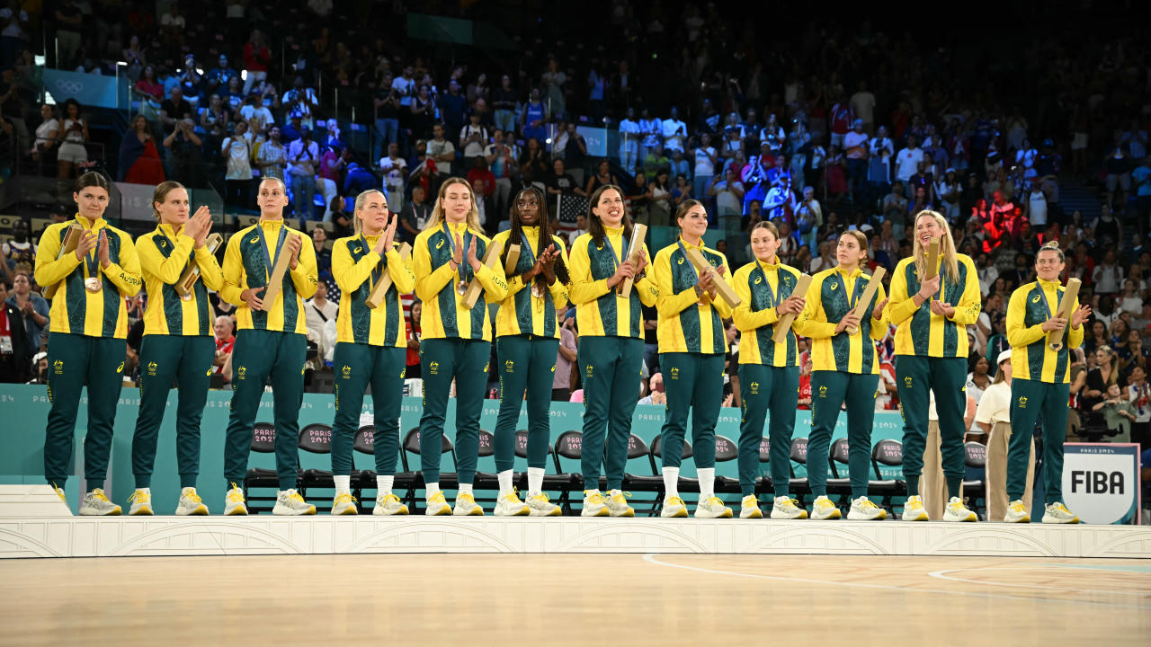 Bronze medallists Australia's players celebrate on the podium after the women's Bronze Medal basketball match between Belgium and Australia during the Paris 2024 Olympic Games at the Bercy Arena in Paris on August 11, 2024. (Photo by Paul ELLIS / AFP) (Photo by PAUL ELLIS/AFP via Getty Images)