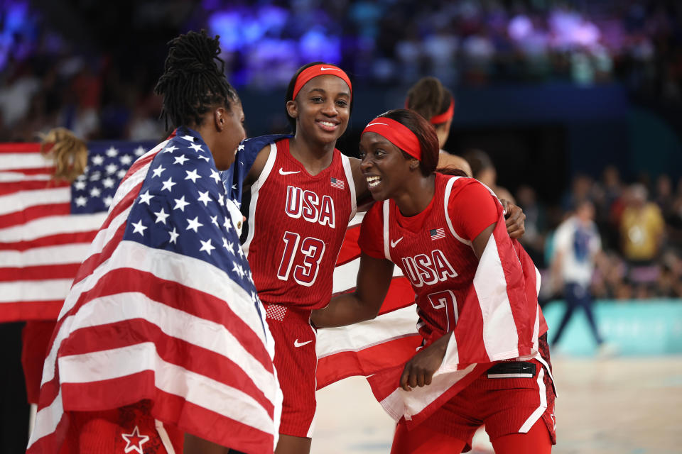 PARIS, FRANCE - AUGUST 11: Jackie Young #13, Kahleah Copper #7, and Chelsea Gray #8 of Team United States celebrate after their team's victory against Team France during the Women's Gold Medal game between Team France and Team United States on day sixteen of the Olympic Games Paris 2024 at Bercy Arena on August 11, 2024 in Paris, France. (Photo by Matthew Stockman/Getty Images)